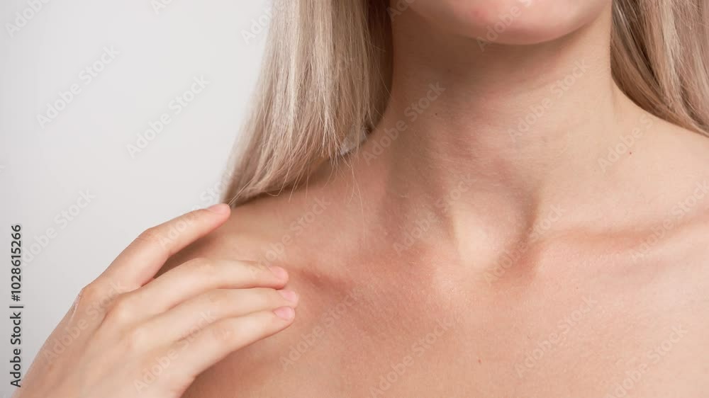 Young blonde woman posing at camera, touches skin on collarbone and chest, isolated on white studio background close up shot. Beauty skin care concept Young blonde woman posing at camera, touches skin on collarbone and chest, isolated on white studio background close up shot. Beauty skin care concept