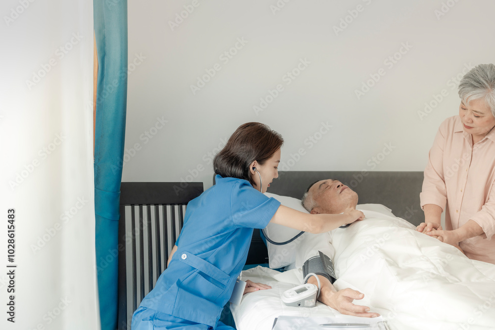 Obraz premium A healthcare woman checks the vital signs of an elderly man in bed while his wife offers comfort by holding his hand. The scene highlights compassionate care, medical attention, and emotional support.