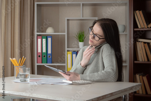 A young beautiful girl works in an office, makes an accounting report.