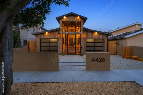 Modern house exterior, featuring a wooden facade and glass garage doors. Southern California