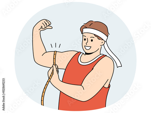 Strong man shows biceps and uses measuring tape to check size of muscles on arm. Strong guy in sportswear boasts about size of biceps and recommends doing bodybuilding or arm wrestling