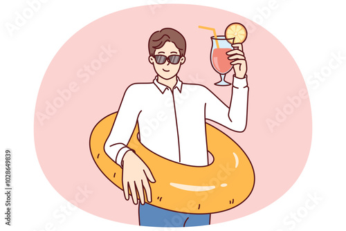 Business man preparing for vacation and tropical travel, holding inflatable ring and cocktail. Businessman in sunglasses on business trip on sunny island resting forgetting about work