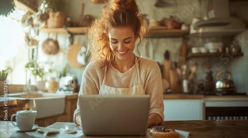 A woman smiles warmly while using her laptop in a bright kitchen, surrounded by cozy elements, capturing a moment of friendly, at-home comfort and connection.