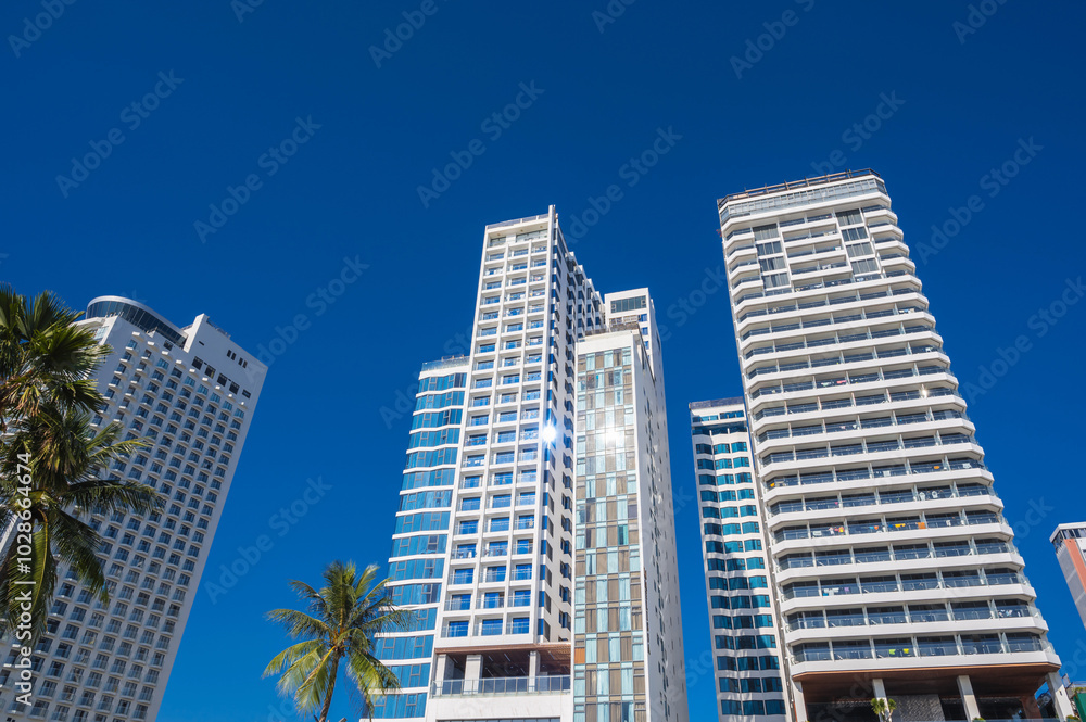 White facades of skyscraper hotels against the blue sky in summer in a resort town in Asia White facades of skyscraper hotels against the blue sky in summer in a resort town in Asia
