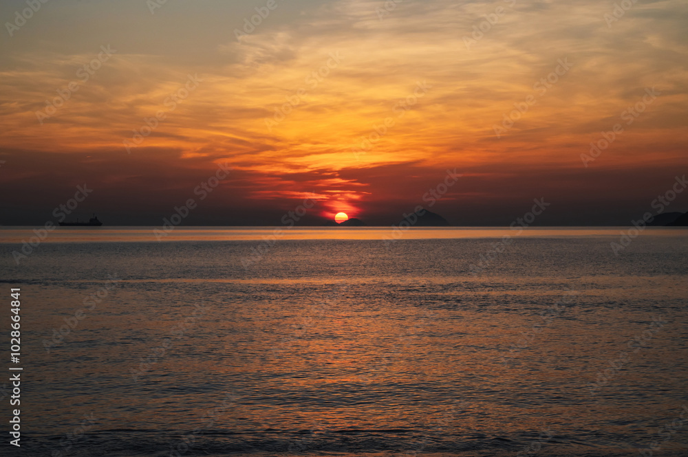 Amazing landscape with orange sunrise in the morning at sea in summer Amazing landscape with orange sunrise in the morning at sea in summer