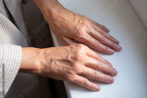 Beautiful hands of mature 50s middle aged woman. Small wrinkles and swollen veins are visible. Beautiful natural manicure.