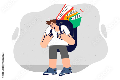 Upset boy with books in backpack suffers from complex educational program in primary school