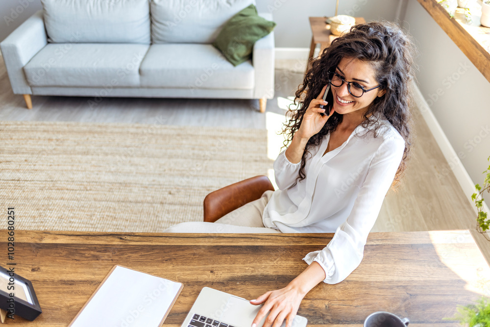 Young Professional Woman Working At Home on Laptop and Phone Young Professional Woman Working At Home on Laptop and Phone
