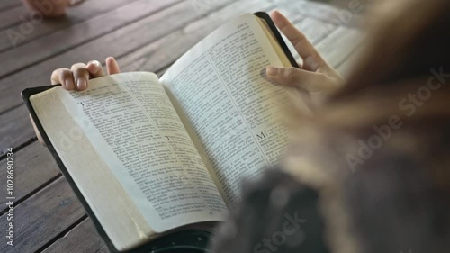 asian woman reading the Christian bible book on wooden table vintage room day time retro style