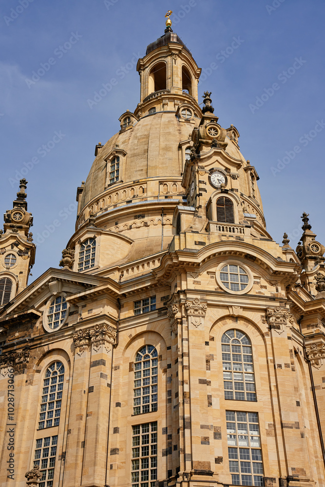Buiilding exterior of Dresden Frauenkirche. Baroque architecture with stonework, large arched windows and grand dome under a clear sky Buiilding exterior of Dresden Frauenkirche. Baroque architecture with stonework, large arched windows and grand dome under a clear sky