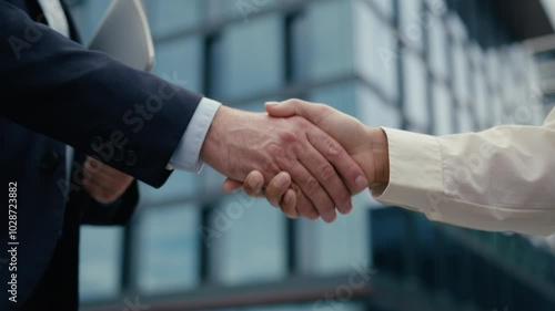 Close up unrecognizable multiracial business meeting in city colleagues Caucasian businessman man male guy African woman businesswoman girl female handshaking shake hands formal greeting hold folder