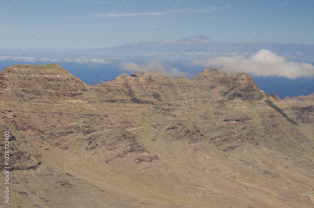 Cliffs in the Special Natural Reserve of Guigui and island of Tenerife in the background. Gran Canaria. Canary Islands. Spain. Cliffs in the Special Natural Reserve of Guigui and island of Tenerife in the background. Gran Canaria. Canary Islands. Spain.