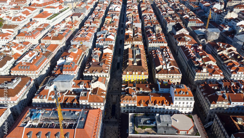 Uma imagem icónica do Terreiro do Paço (também conhecido como Praça do Comércio), situada na Baixa Pombalina, em Lisboa. A ampla praça está rodeada por majestosos edifícios de cor amarela com arcadas  photo