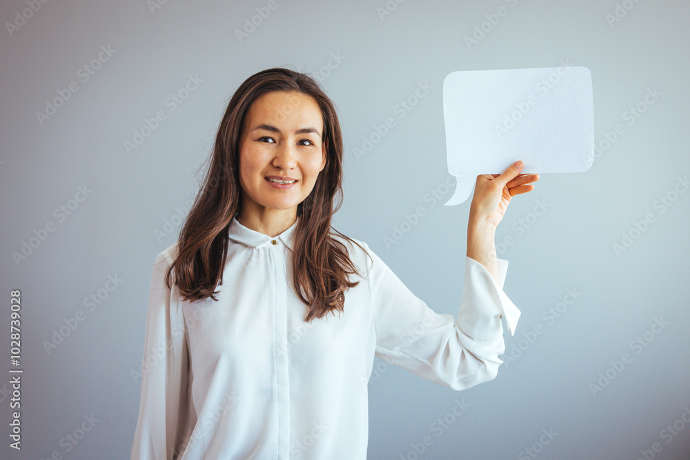 Smiling Woman Holding Paper Speech Bubble Against Gray Background Smiling Woman Holding Paper Speech Bubble Against Gray Background