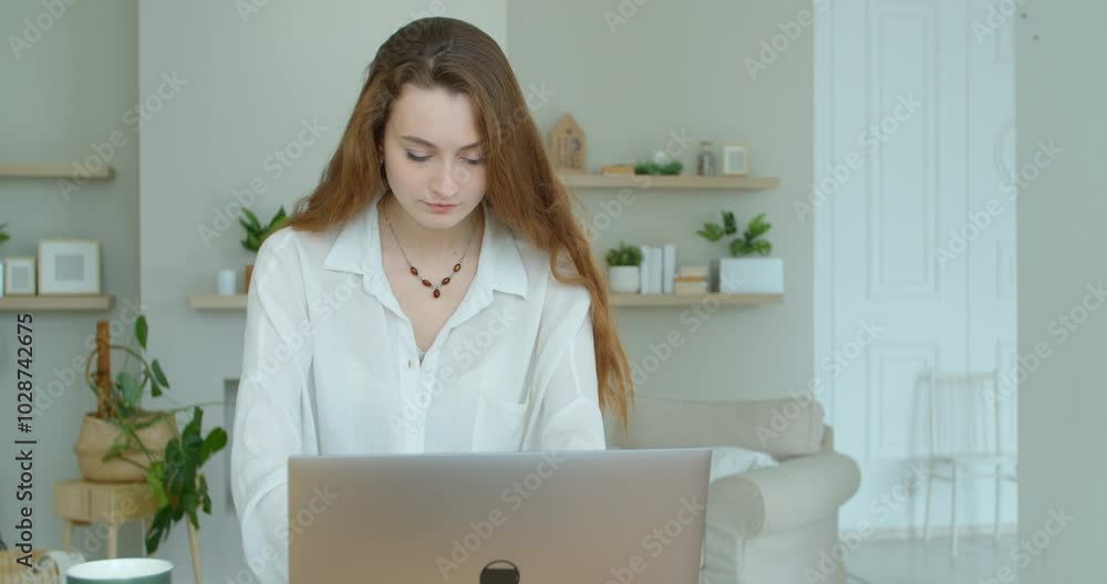 Serious young woman freelancer working on freelance from home typing email on laptop, focused girl using computer for study online at home sitting on couch, female user busy on distance internet job. Serious young woman freelancer working on freelance from home typing email on laptop, focused girl using computer for study online at home sitting on couch, female user busy on distance internet job.