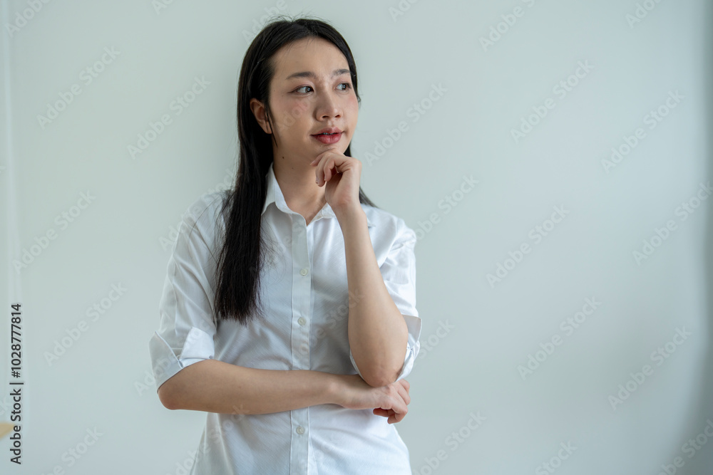 Young asian woman thinking with hand on chin Young asian woman thinking with hand on chin