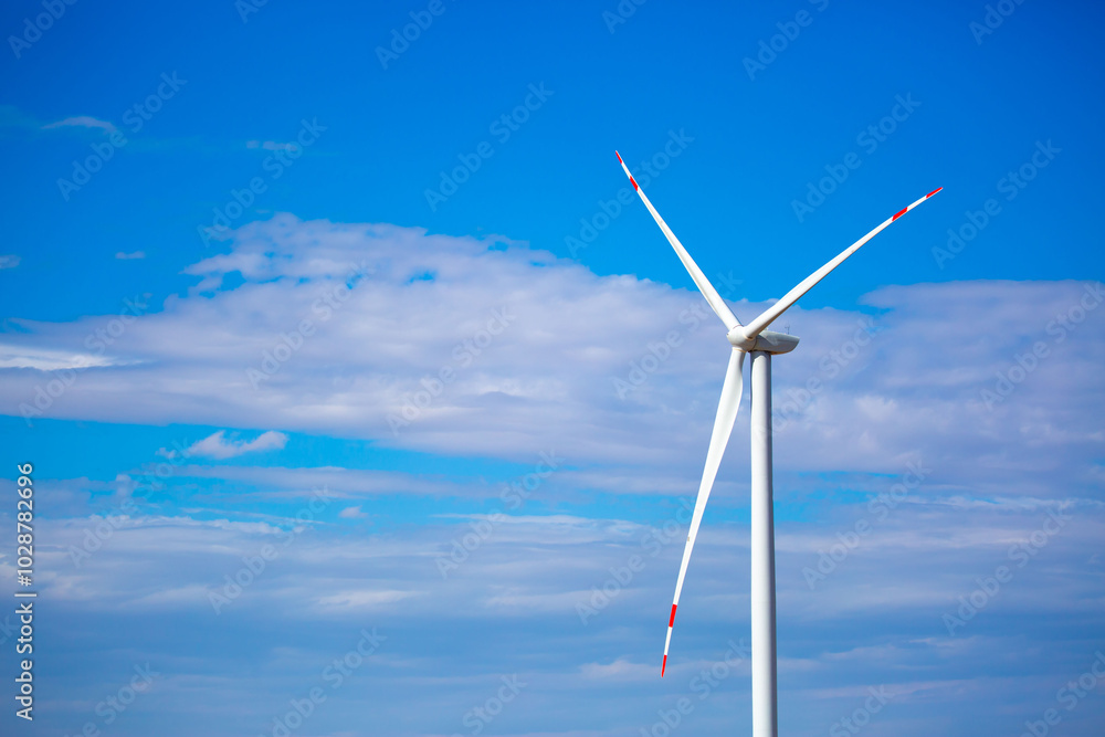 Fleet of power generators in motion. The blades of the wind farm rotate against the sky. The concept of extracting electricity from renewable sources. Wind turbine to generate electricity. Fleet of power generators in motion. The blades of the wind farm rotate against the sky. The concept of extracting electricity from renewable sources. Wind turbine to generate electricity.