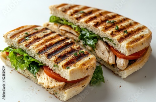 Grilled chicken sandwich with fresh lettuce and tomatoes on a white background