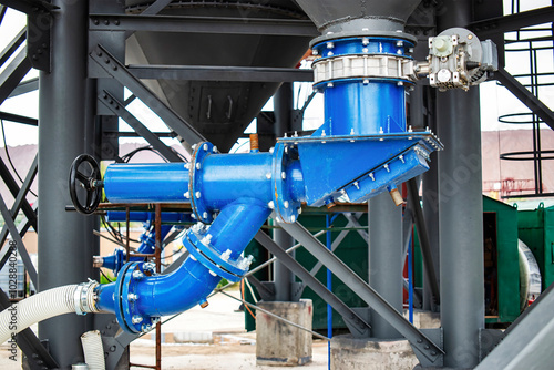 Industrial concrete plant with cement bins and batchers actively producing cement mortar at a construction site photo