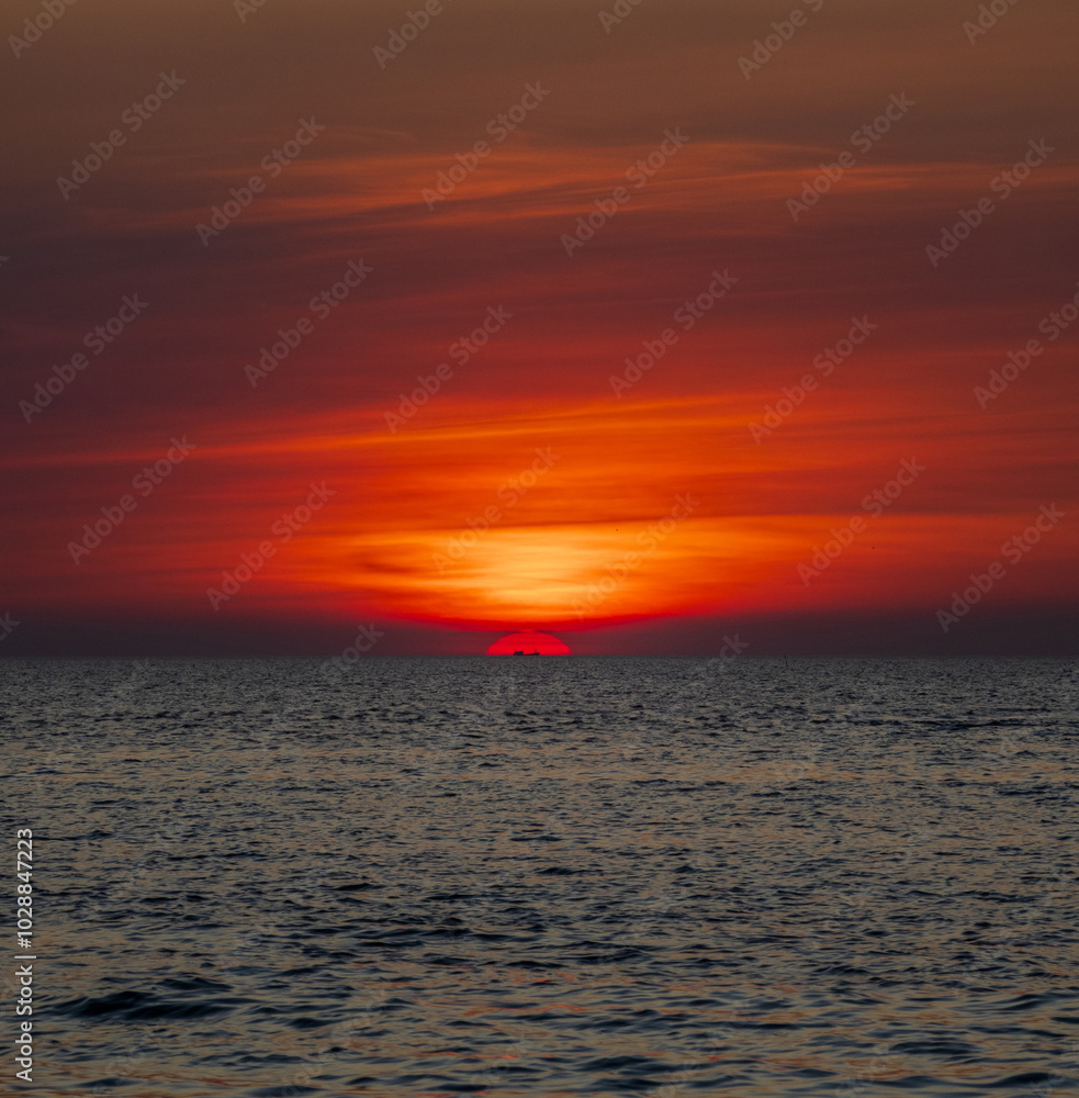 Naklejka premium Sunset sea vertical view landscape horizon beautiful summer season shore nobody wind soft wave cool holiday look calm big sunset sky twilight evening day time nature tropical coast ocean water travel