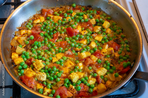 Spicy matar paneer or cottage cheese vegetarian curry cooked with tomatoes Indian style in a frying pan. photo