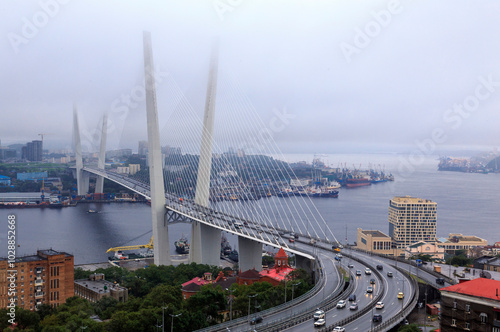 Vladivostok, Russia - September 7, 2019: Aerial view of Golden Bridge over Golden Horn Bay with foggy background