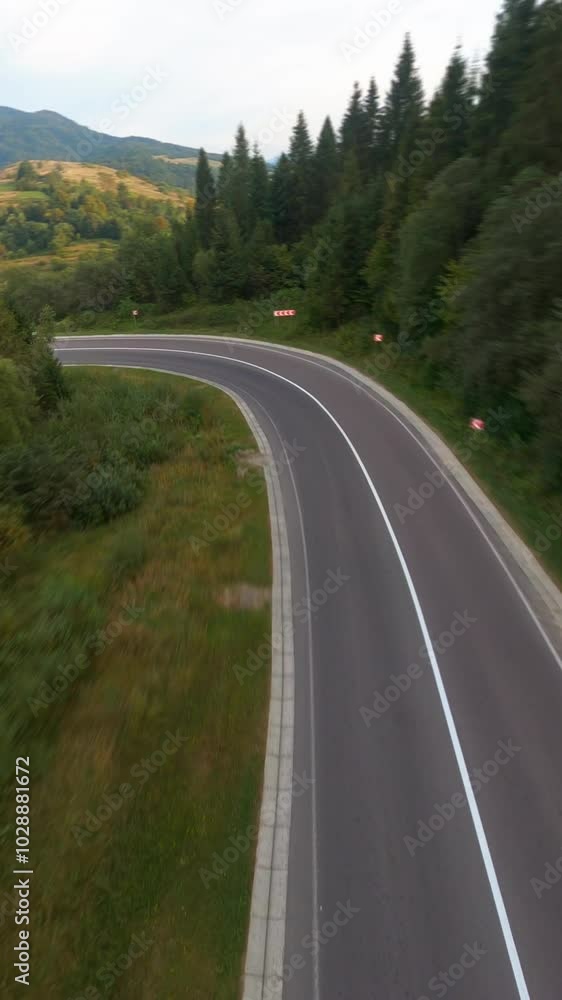 Flying FPV drone over beautiful country highway road in picturesque valley. Summer green forest. Inspiring roadtrip. Flying FPV drone over beautiful country highway road in picturesque valley. Summer green forest. Inspiring roadtrip.