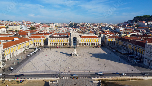 Uma imagem icónica do Terreiro do Paço (também conhecido como Praça do Comércio), situada na Baixa Pombalina, em Lisboa. A ampla praça está rodeada por majestosos edifícios de cor amarela com arcadas  photo