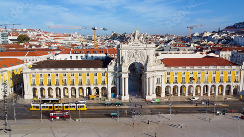 Uma imagem icónica do Terreiro do Paço (também conhecido como Praça do Comércio), situada na Baixa Pombalina, em Lisboa. A ampla praça está rodeada por majestosos edifícios de cor amarela com arcadas  photo