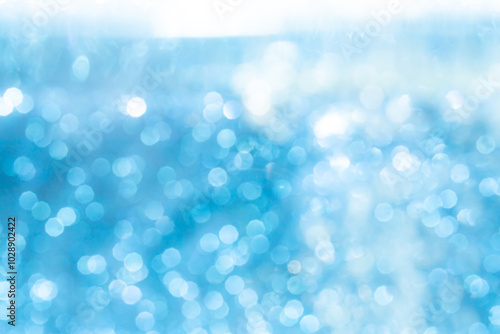 Abstract blurred blue and white bokeh lights background with soft gradient colors, creating a dreamy and serene effect, perfect for festive and decorative use.