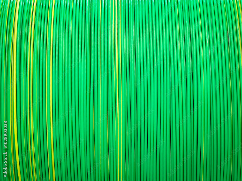 Vivid green and yellow plastic coated cables tightly coiled, showcasing a symmetrical and colorful pattern. Vivid green and yellow plastic coated cables tightly coiled, showcasing a symmetrical and colorful pattern.