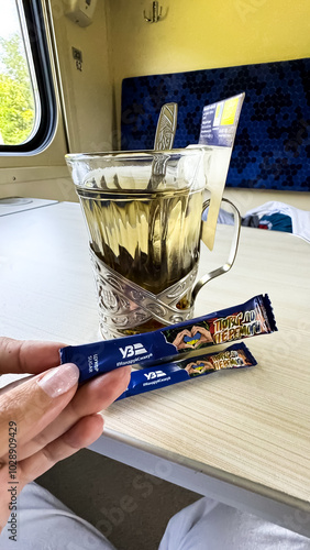 Packages of sugar against the background of a glass of tea. Ukraine, Ukrzaliznytsia, 2024 year photo