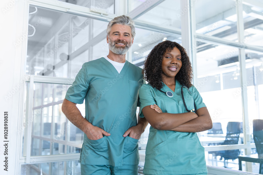 Two doctors looking contented and confident while standing in the hospital corridor Two doctors looking contented and confident while standing in the hospital corridor