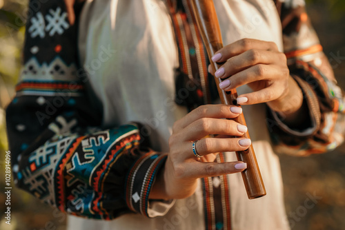 Hand Of Woman Playing On Woodwind Flute - Ukrainian Wooden Sopilka In Forest photo