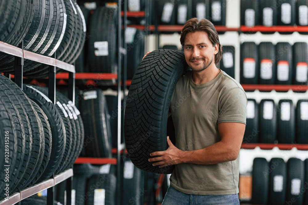 Customer is choosing the tire. Man is in the tire fitting car service Customer is choosing the tire. Man is in the tire fitting car service