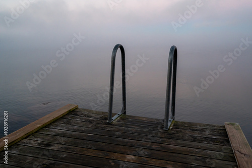 Bathing ladder on jetty on misty cold morning i October photo