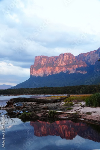 Tepuy en canaima y la gran sabana vista desde isla orquídea mientras el atardecer pinta las montañas. se aprecia el rio carrao 