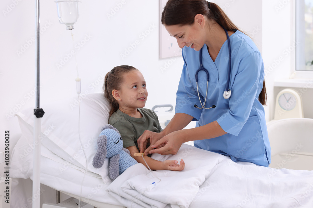 Doctor examining little girl on bed at hospital Doctor examining little girl on bed at hospital