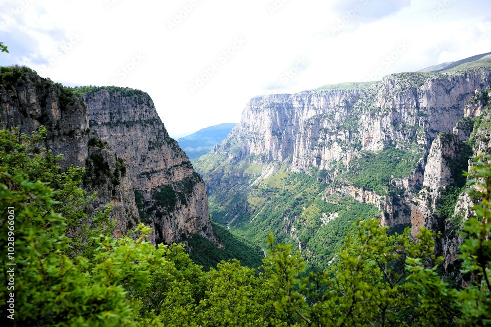 Panoramic view over the steep and green cliffs of the Vikos Gorge in Epirus, Greece on a summer's day. The gorge in the Pindus Mountains is one of the deepest gorges in the world. Hiking in Greece
Panoramic view over the steep and green cliffs of the Vikos Gorge in Epirus, Greece on a summer's day. The gorge in the Pindus Mountains is one of the deepest gorges in the world. Hiking in Greece