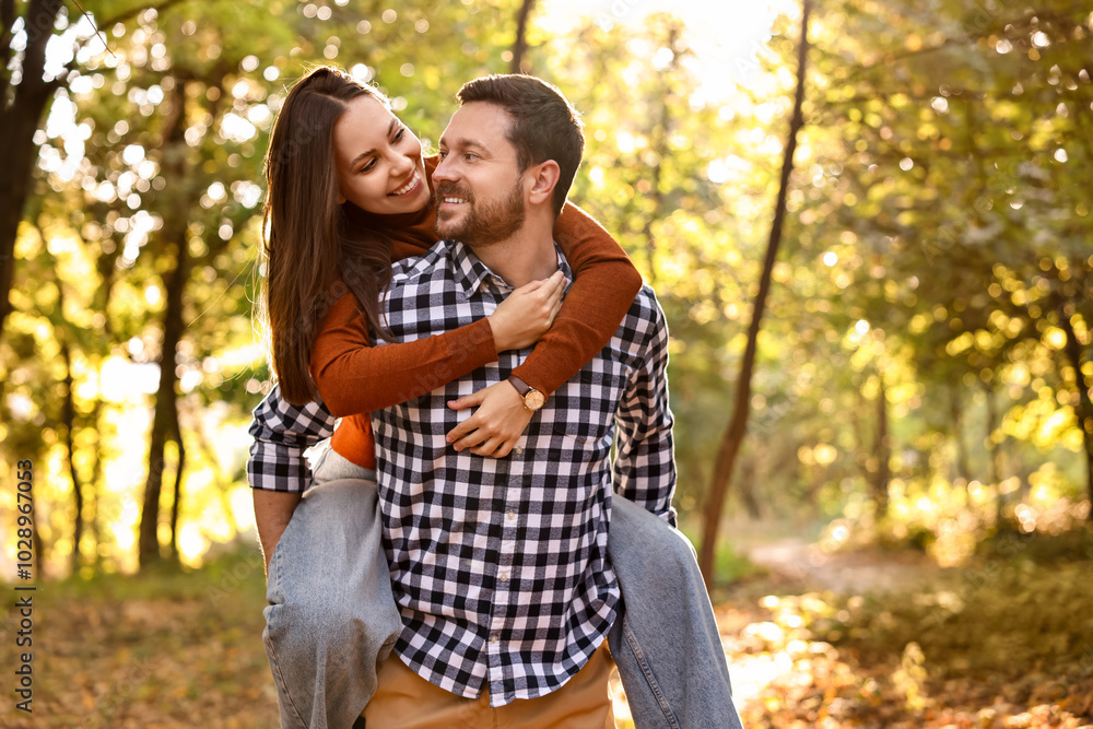 Beautiful couple having fun together in park on autumn day Beautiful couple having fun together in park on autumn day