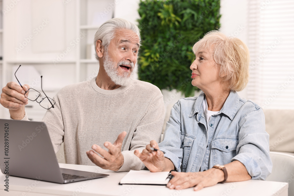 Pension savings. Senior couple planning budget at white table indoors Pension savings. Senior couple planning budget at white table indoors