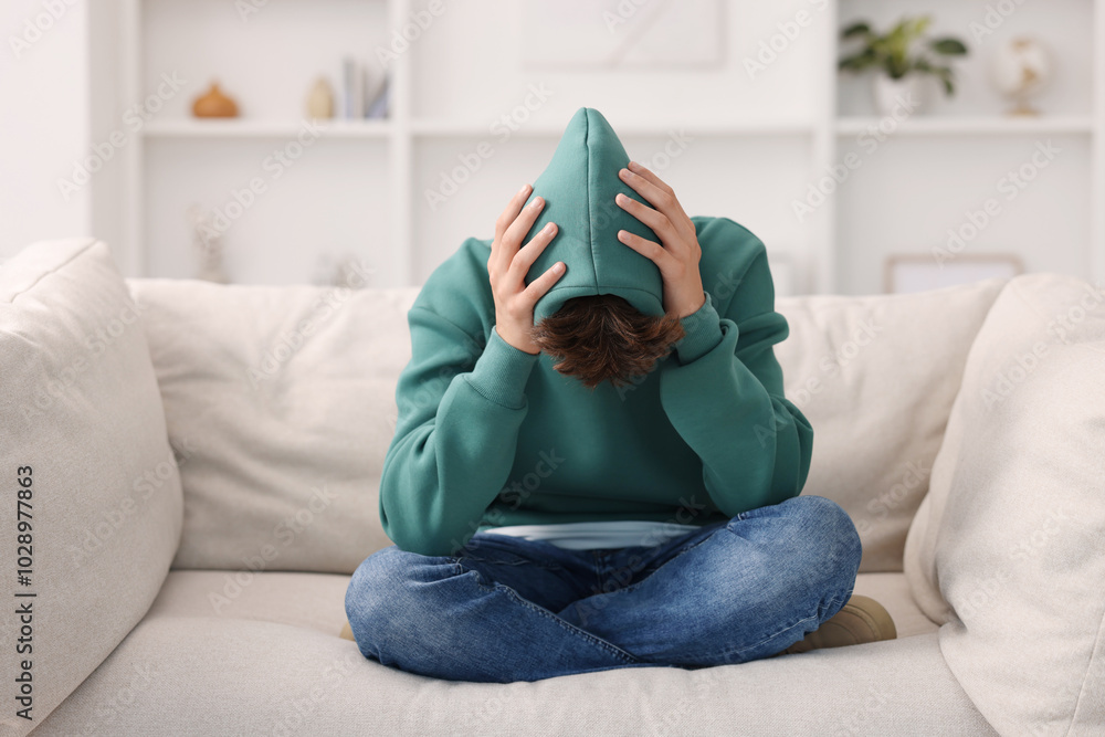 Obraz premium Loneliness concept. Sad teenage boy on sofa at home