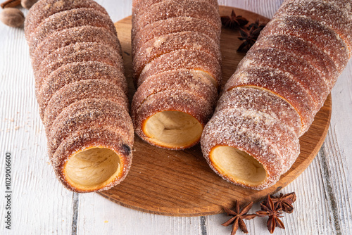 Traditional East Europe Christmas sugar glazed dessert chimney cake, trdlo or trdelnik, sweet aromatic winter seasonal street food with cinnamon and spices