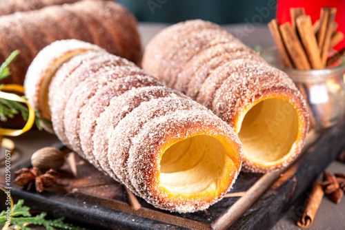 Fototapeta Naklejka Na Ścianę i Meble -  Traditional East Europe Christmas sugar glazed dessert chimney cake, trdlo or trdelnik, sweet aromatic winter seasonal street food with cinnamon and spices