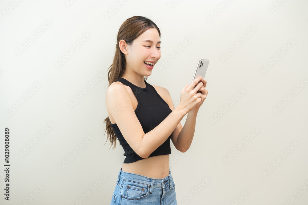 Happy asian young woman using mobile smart phone, read good news online, laugh excited getting offer, great positive surprise, celebrate success on smartphone. Smile girl isolated on white background. Happy asian young woman using mobile smart phone, read good news online, laugh excited getting offer, great positive surprise, celebrate success on smartphone. Smile girl isolated on white background.