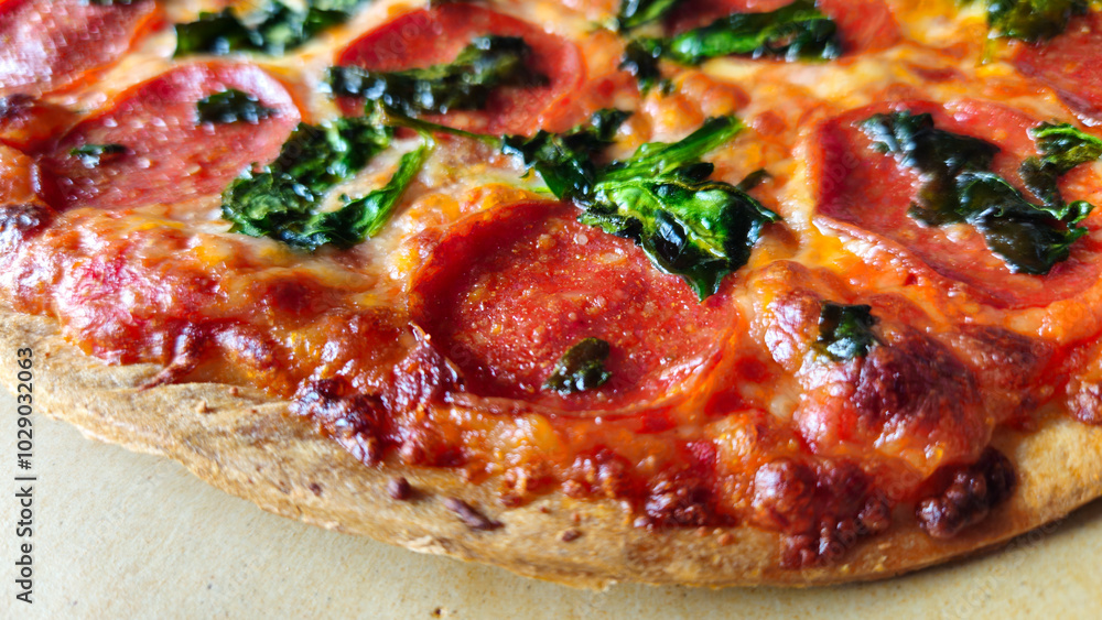 macro closeup of thin crust pepperoni pizza with spinach background macro closeup of thin crust pepperoni pizza with spinach background