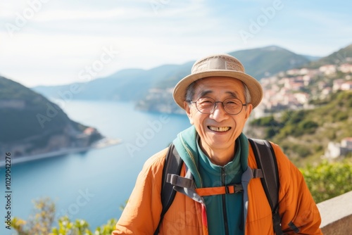 Portrait of a happy asian man in his 80s sporting a technical climbing shirt on picturesque seaside village