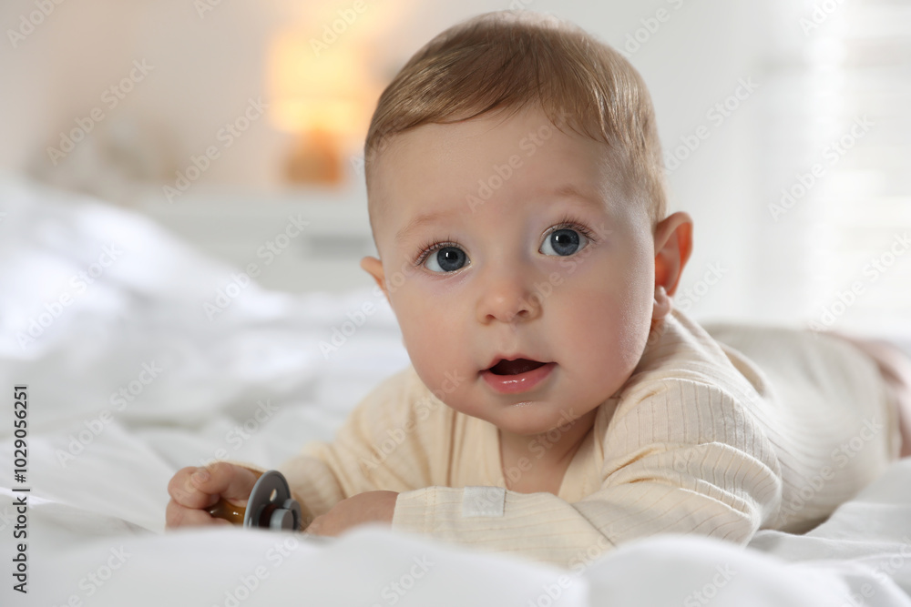 Cute little baby with pacifier on bed indoors Cute little baby with pacifier on bed indoors