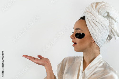 Young attractive Caucasian woman receive  antiwrinkle therapy with black eye patches isolated on white photo