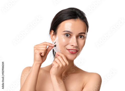 Beautiful woman peeling off face mask on white background